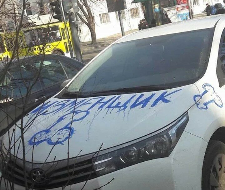Парень нацарапал на борту чужого автомобиля какой то рисунок