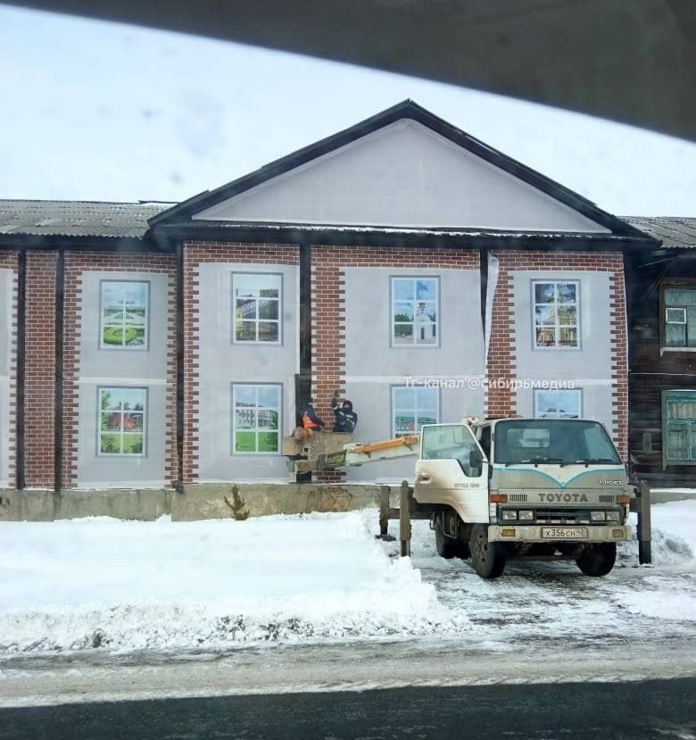 В Кемеровской области жилой деревянный барак завесили баннером с фотографией нового дома перед приездом губернатора.