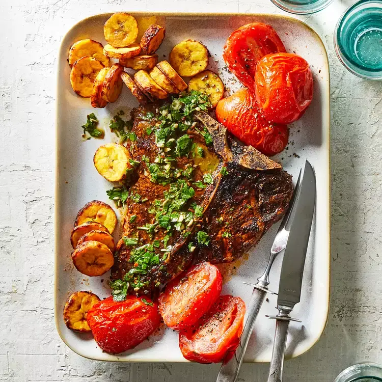 Стейк во фритюре с помидорами и бананами.